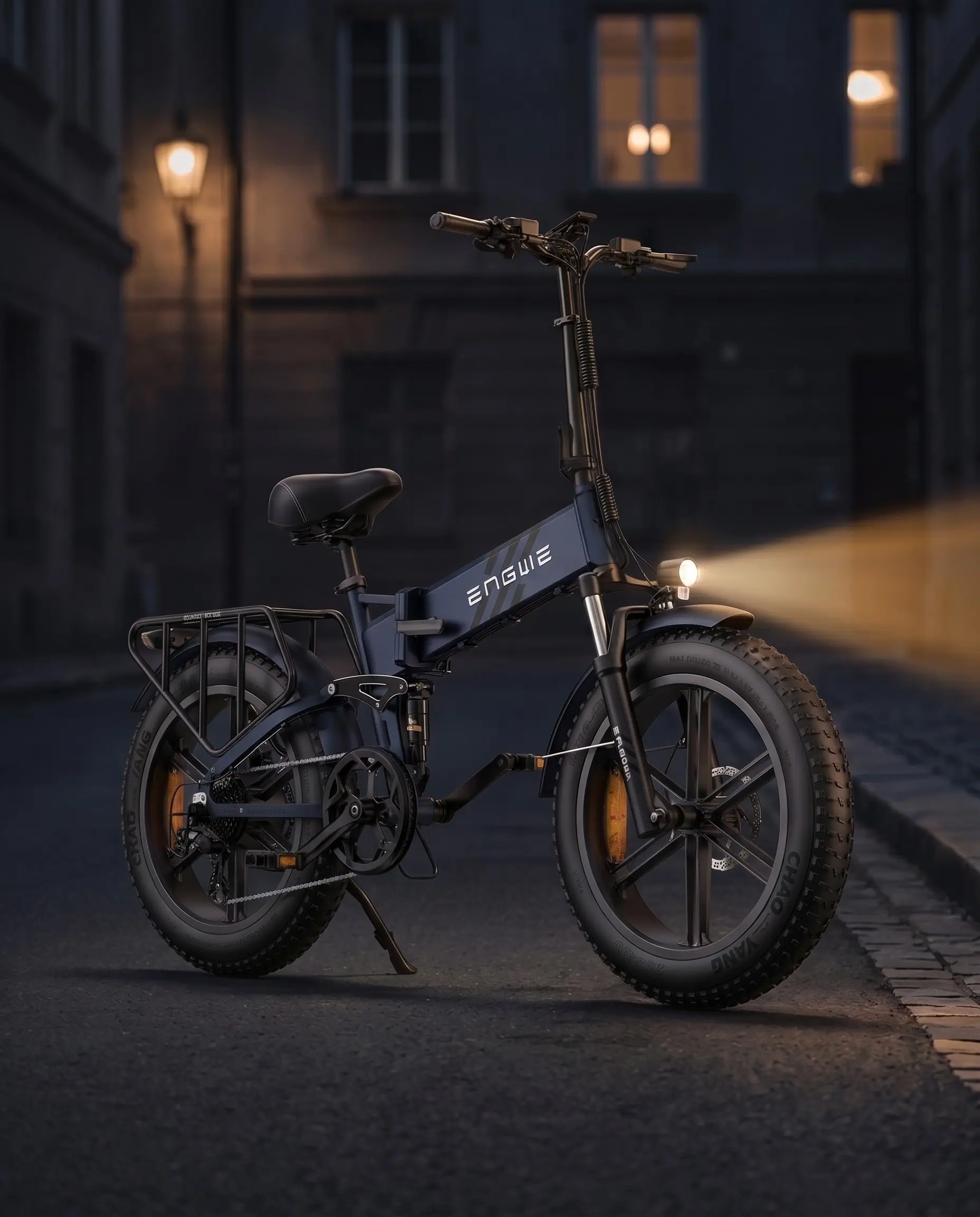 ENGWE Engine Pro 2.0 in Mitternachtsblau, nachts auf einer gepflasterten Straße geparkt, Scheinwerfer eingeschaltet